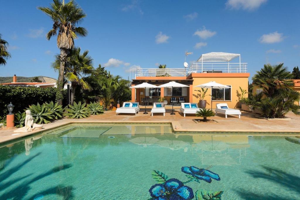 uma grande piscina com uma casa ao fundo em Villa Marissa - Ibiza em Sant Francesc de s'Estany