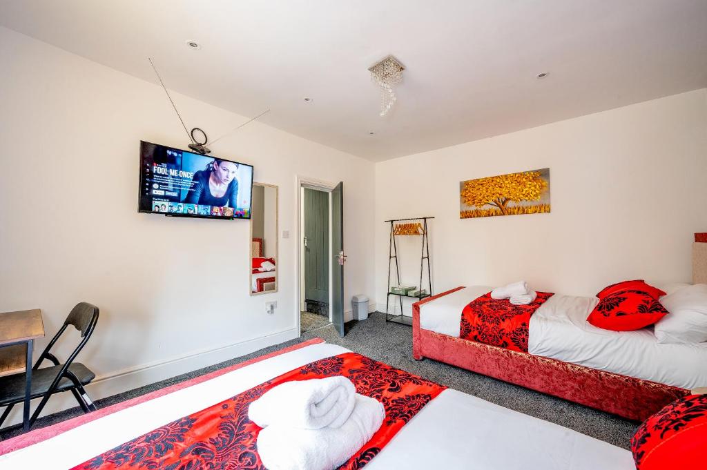 a bedroom with two beds and a tv on the wall at *RB10W* For your most relaxed & Cosy stay + Free Parking + Free Fast WiFi * in Belle Isle