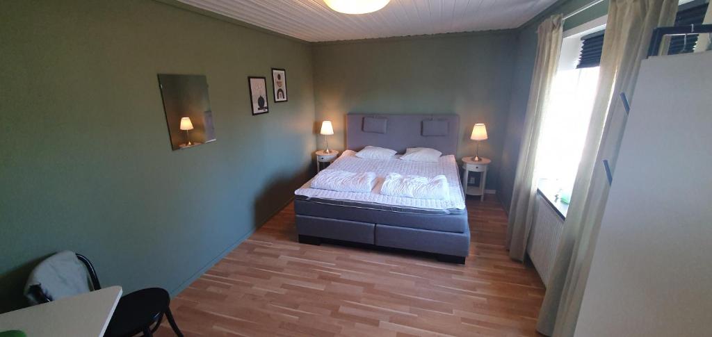 a bedroom with a bed with white sheets and a window at Ängdala Camping på Österlen in Kivik