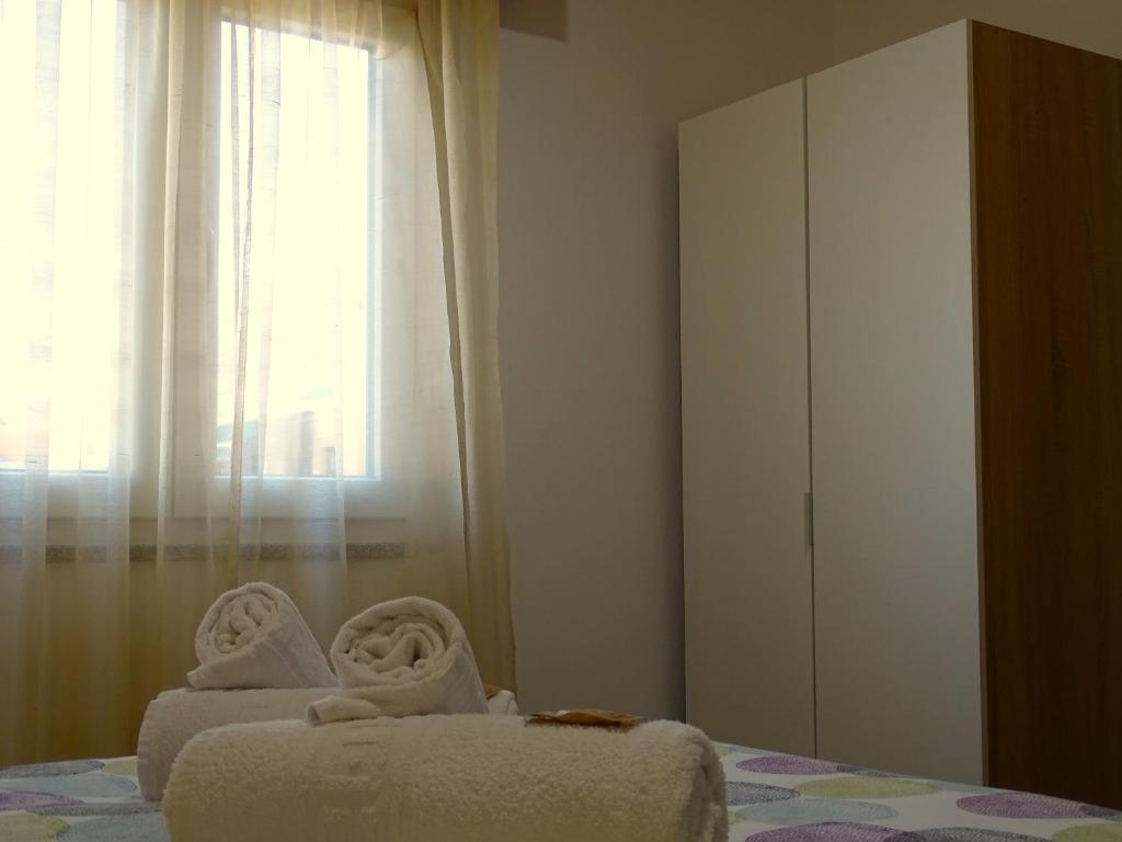 Un dormitorio con dos toallas en una cama con ventana. en CHAVE D'OURO HOUSE by Stay in Alentejo, en Vila Nova de Milfontes