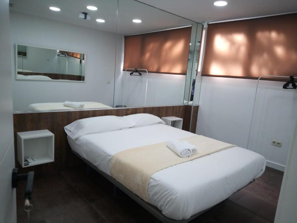 a bedroom with a large white bed and a mirror at Dreams Low Cost in Madrid