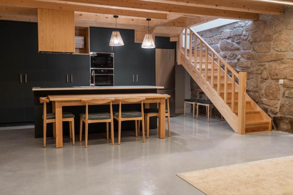 uma cozinha com uma mesa de madeira e uma escada em Casa Da Eira em Vila Real