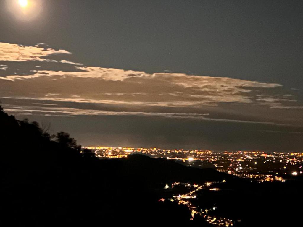 una vista di una città di notte con la luna di Casa Borgo Pietro a Galzignano