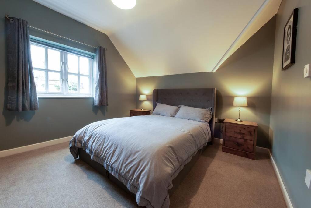 ein Schlafzimmer mit einem großen Bett und einem Fenster in der Unterkunft The Nest - cosy and quiet 1 bed central in Buckinghamshire