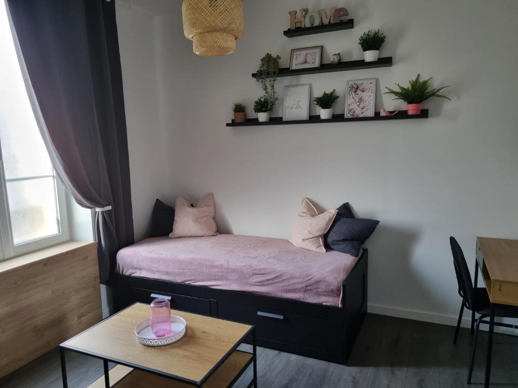 a small bedroom with a bed and a table at La Fourmi in Soissons