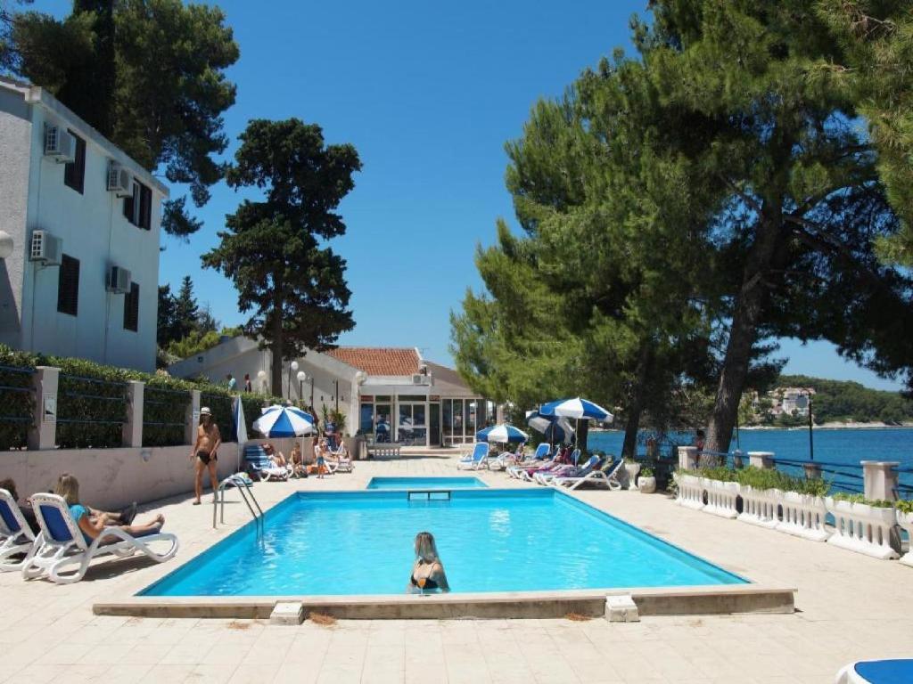 a little girl is sitting in a swimming pool at Lumbarda Resort Apartments in Lumbarda