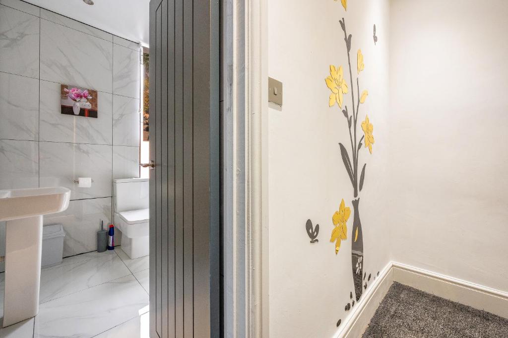 a bathroom with yellow flowers on the wall at *RB10W* For your most relaxed &amp; Cosy stay + Free Parking + Free Fast WiFi * in Belle Isle