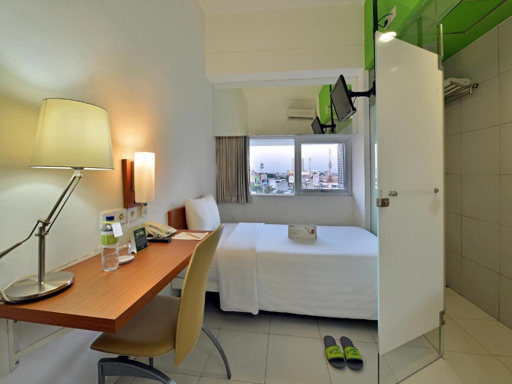 Postel nebo postele na pokoji v ubytování Whiz Hotel Pemuda Semarang