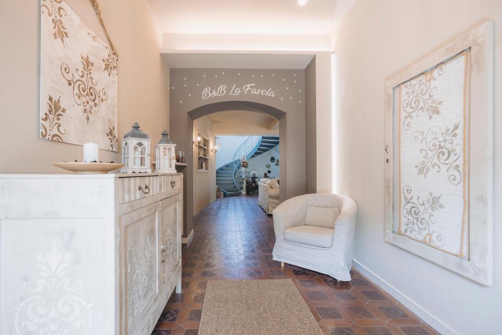um corredor com um quarto branco com uma cadeira e uma parede em La Favola em Soriso