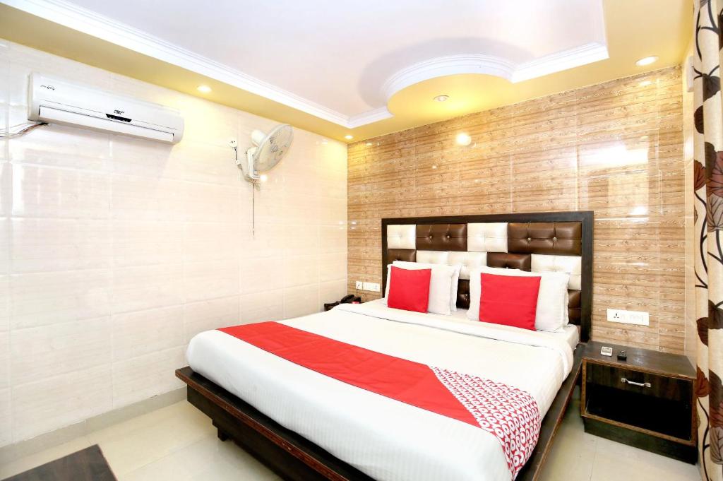 una camera da letto con un grande letto con cuscini rossi di Super OYO Hotel Continental Inn 42 a Chandīgarh