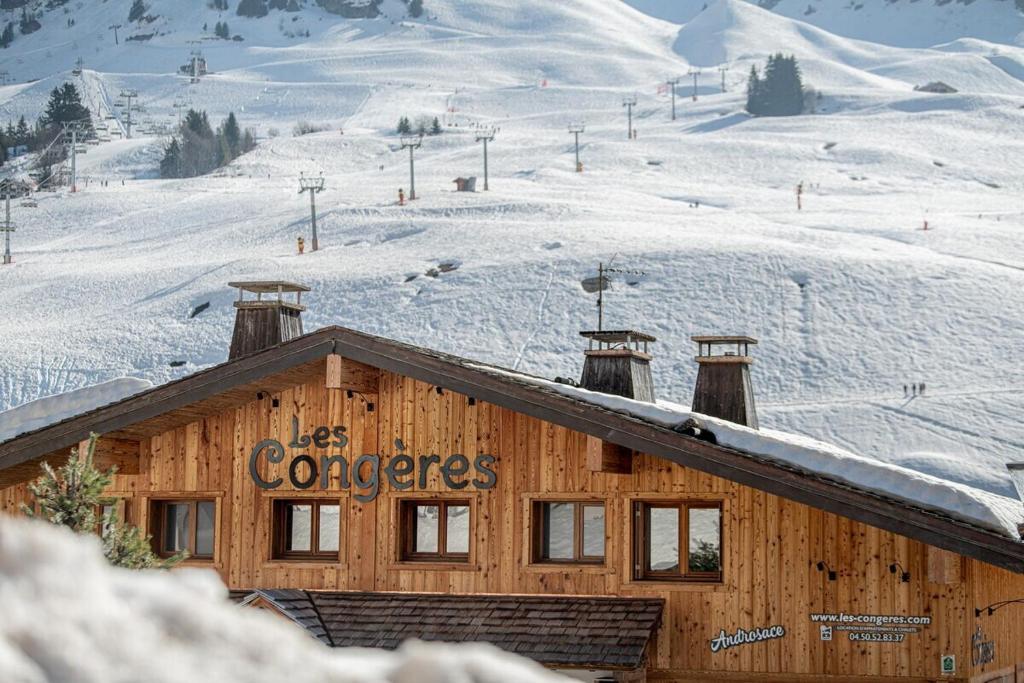 a building with a sign on it in the snow at Les Congères in Le Grand-Bornand