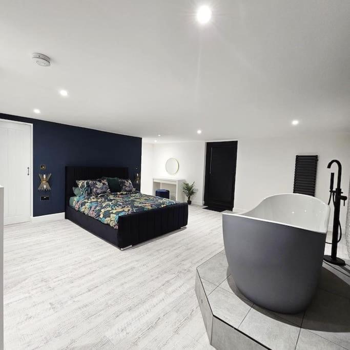 a large bedroom with a bed and a bath tub at Relaxation & Romance in Manston