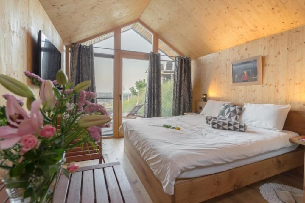 a bedroom with a bed and a large window at Glamping house Julija - Wellness & View in Ivanjkovci