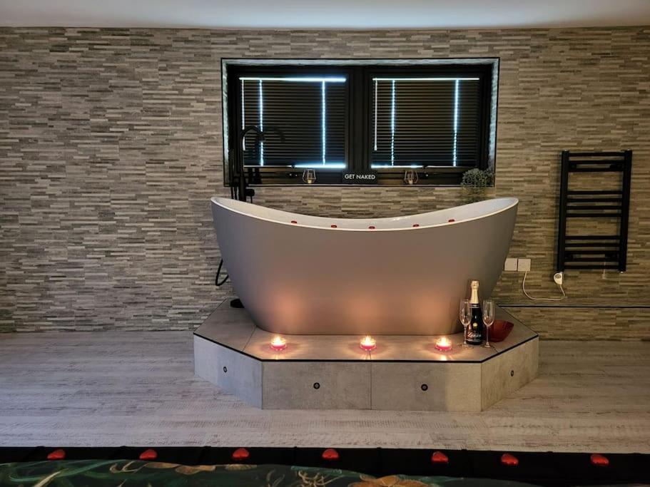 a large bath tub with lights in a bathroom at Relaxation & Romance in Manston