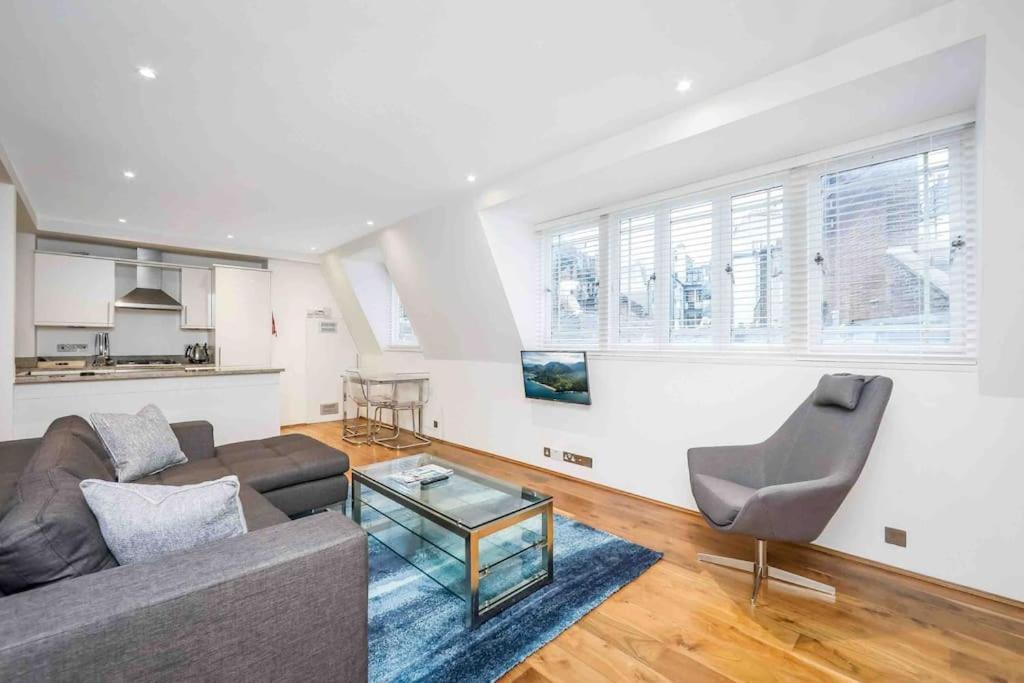 a living room with a couch and a table at Oxford Circus Station Apartment- Mayfair! in London