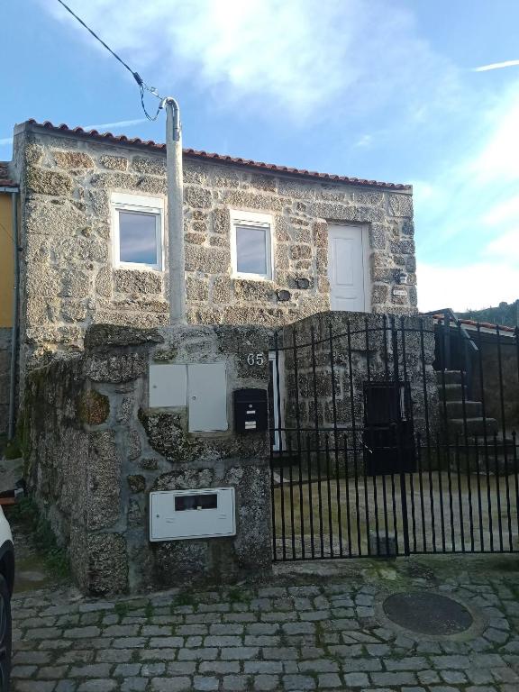 a stone house with a fence in front of it at Cottage Aldeia Da Serra - historic areas of Portugal in Celorico da Beira