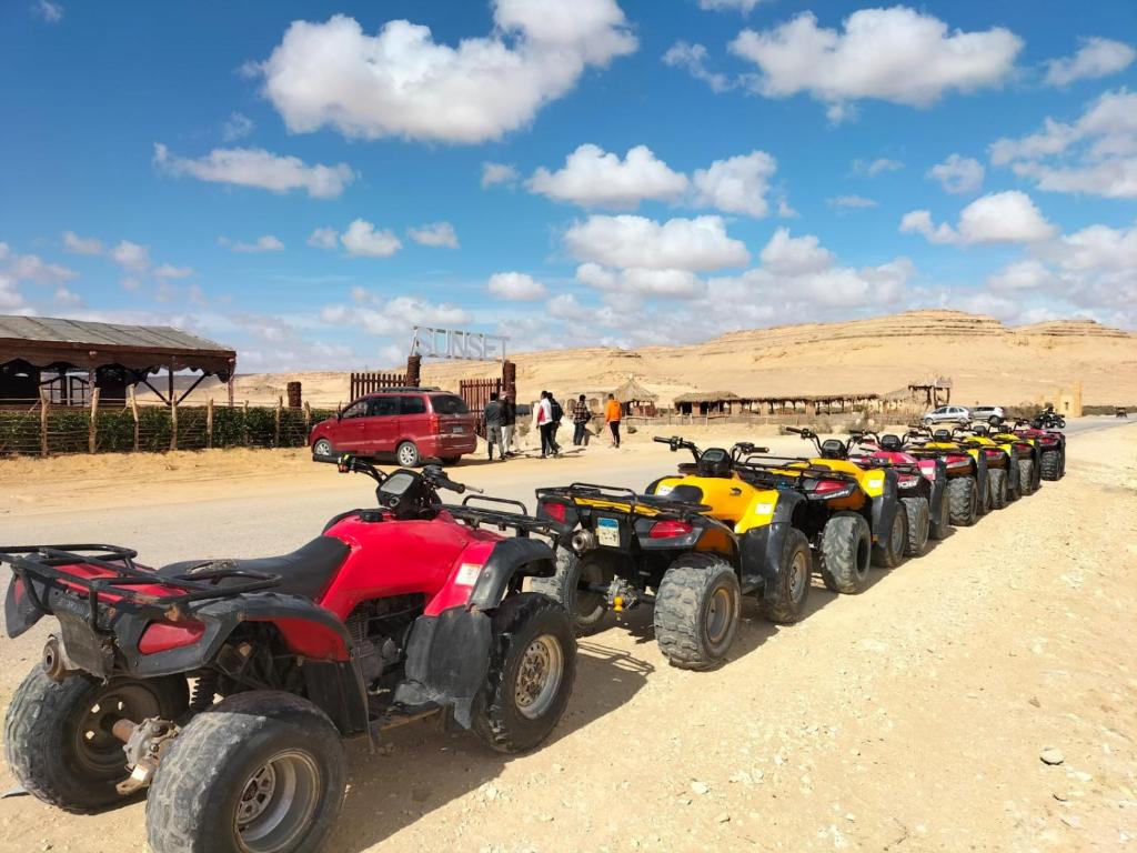 una fila de ATV estacionados en el desierto en Sunset Camp, en Dār as Salām