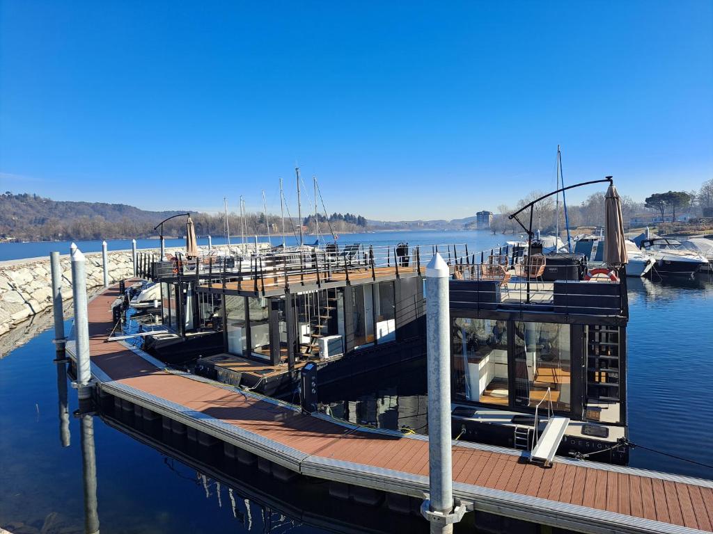 a dock with a marina with boats in the water at Floating Experience Black Pearl, Lago Maggiore in Dormelletto