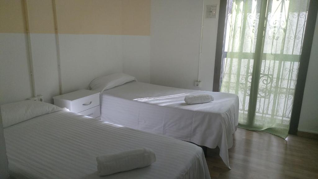 een kamer met 2 bedden en een raam bij Arce apartamentos in Sevilla