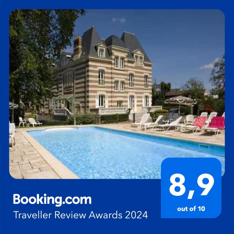 une grande maison avec une piscine devant dans l'établissement Appartement avec piscine, 100m plage et hypercentre, à Cabourg