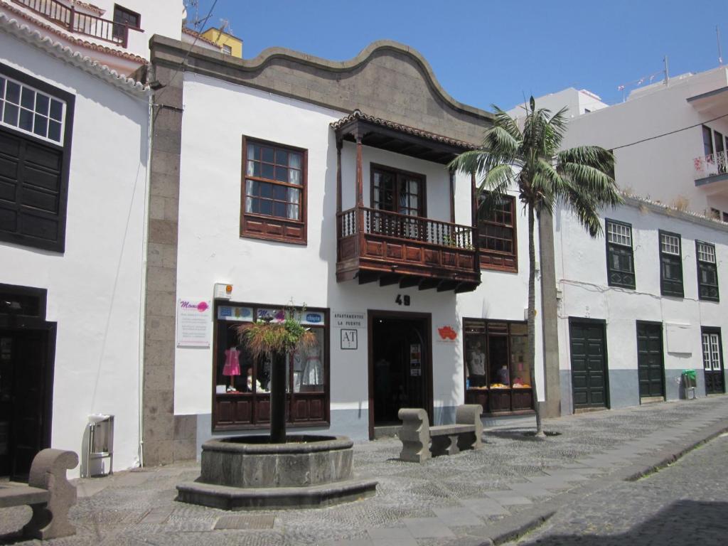 a white building with a palm tree in front of it at Apartamentos La Fuente in Santa Cruz de la Palma