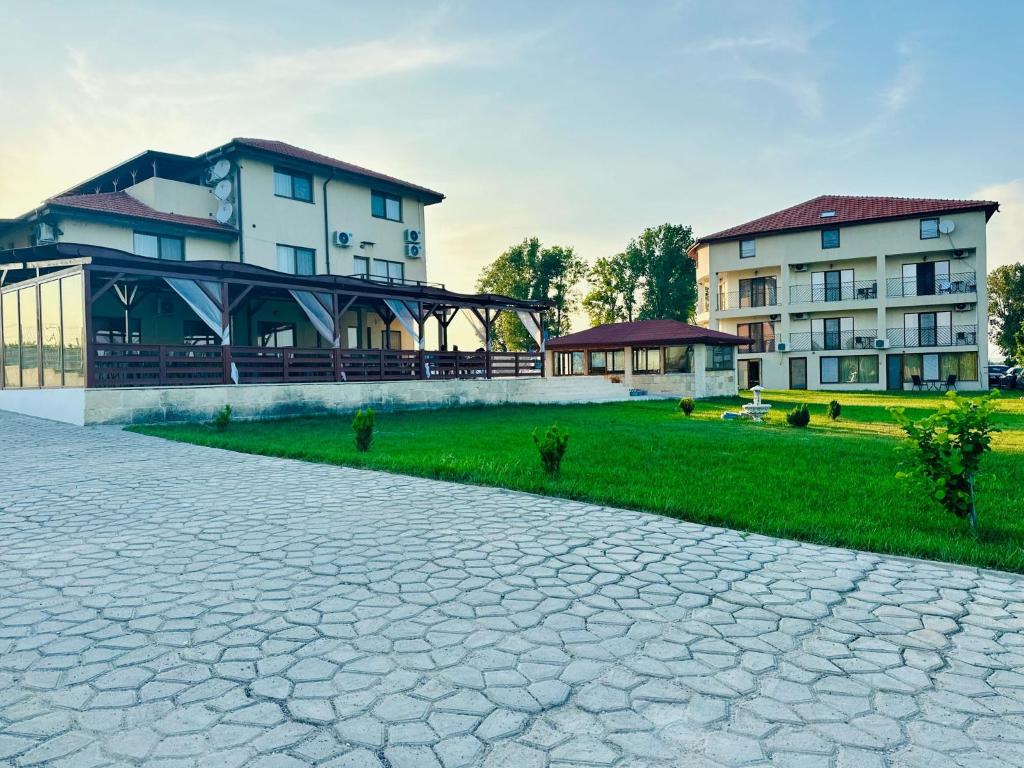 a group of buildings with a cobblestone road in front at Pensiunea Fabian in Jurilovca