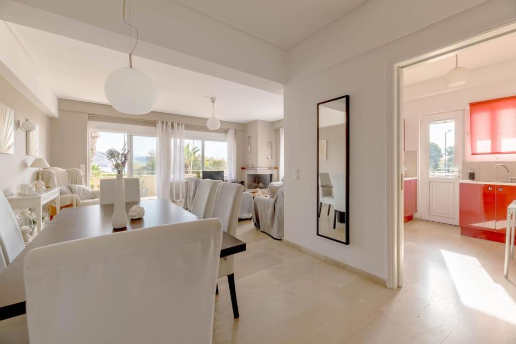 a white dining room with a table and chairs at The HostMaster Beachside Retreat in Vari