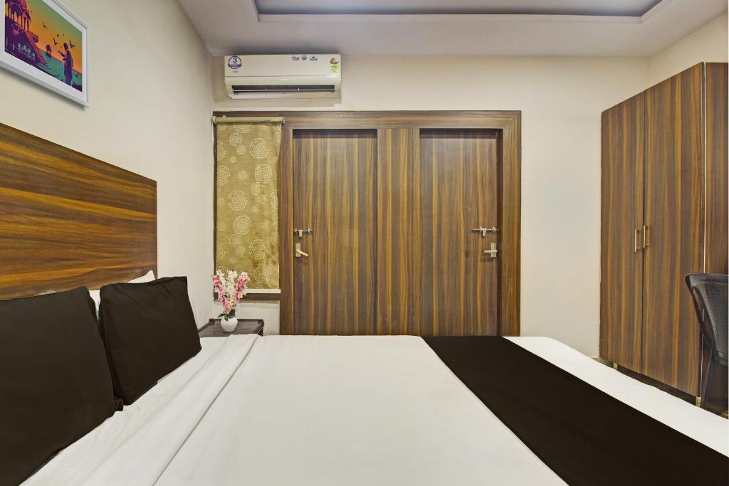 a bedroom with a bed and wooden doors at OYO Hotel Srujana Stay Inn Opp Public Gardens Nampally in Hyderabad