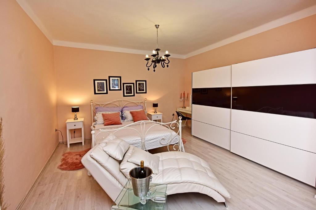 1 dormitorio con cama blanca y sofá en Apartments Villa Herak, en Poreč
