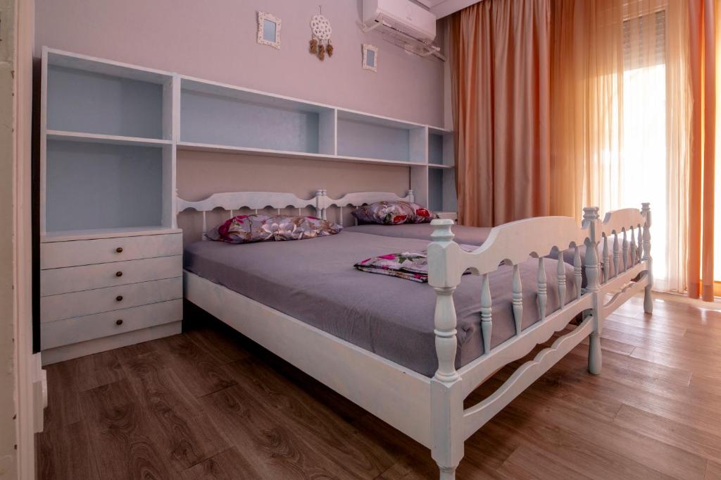 a bedroom with a large white bed with shelves at Jenny's Coastal escape in Nea Kallikrateia