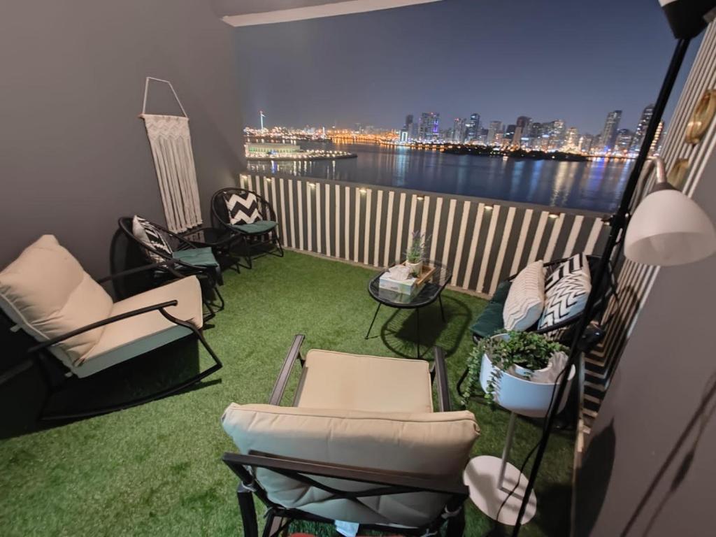 a balcony with chairs and a view of the water at Luxury Corniche Apartment in Sharjah