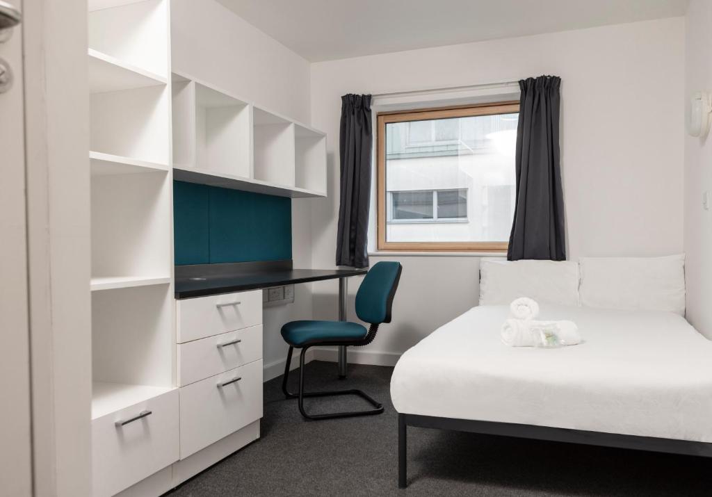 a bedroom with a bed and a desk and a chair at Wenlock Court in Luton