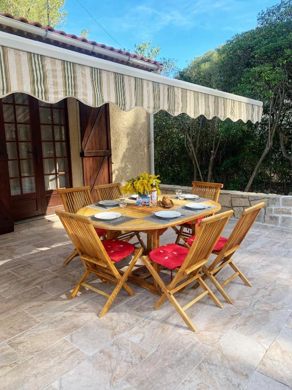 une table et des chaises en bois sur une terrasse dans l'établissement Villa familiale à Sanary, climatisée, plage à pieds, à Sanary-sur-Mer