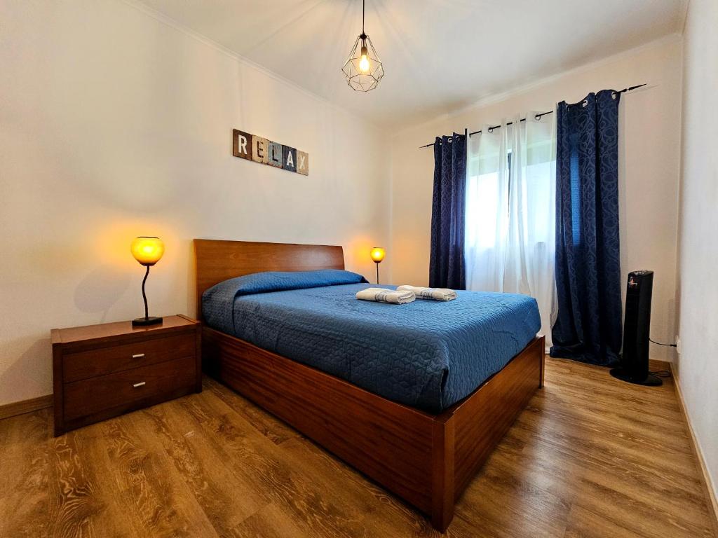 a bedroom with a bed and two lamps and a window at Sweet Blue Home in Ponta Delgada