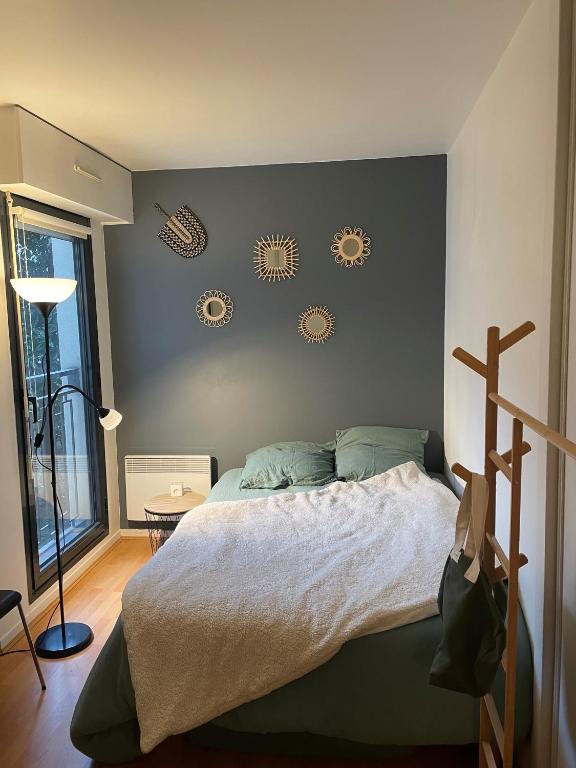 - une chambre avec un lit et quelques assiettes murales dans l'établissement 2 pièces Asnières Idéal JO 2024, à Asnières-sur-Seine