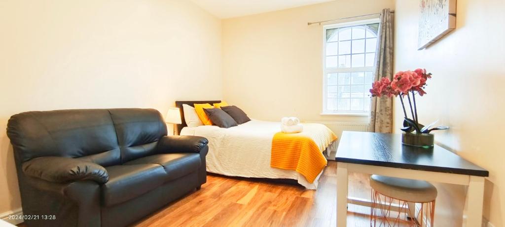 ein Schlafzimmer mit einem Bett und einem Ledersessel in der Unterkunft Rose 4 at Hammersmith in London