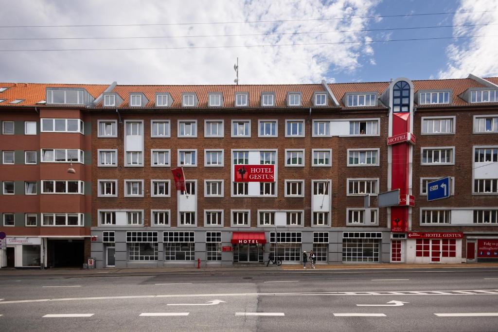 un grand bâtiment en briques avec un panneau devant lui dans l'établissement Milling Hotel Gestus, à Aalborg