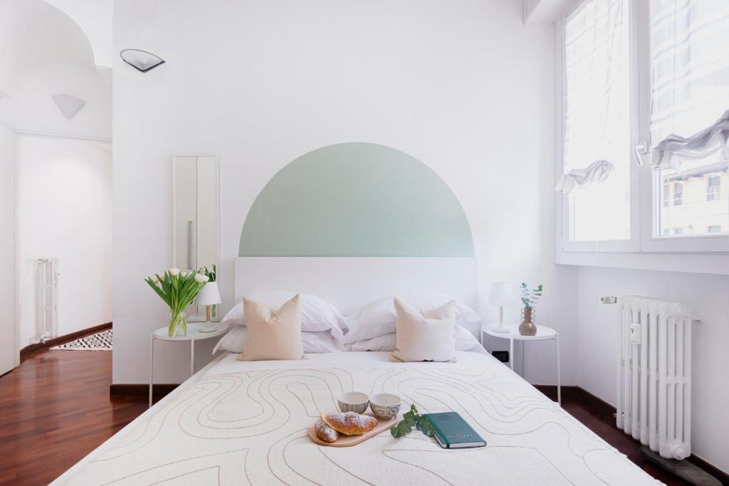 um quarto branco com uma cama grande e uma bandeja de comida. em Stylish and Cozy apt close to Naviglio (MUDEC) em Milão