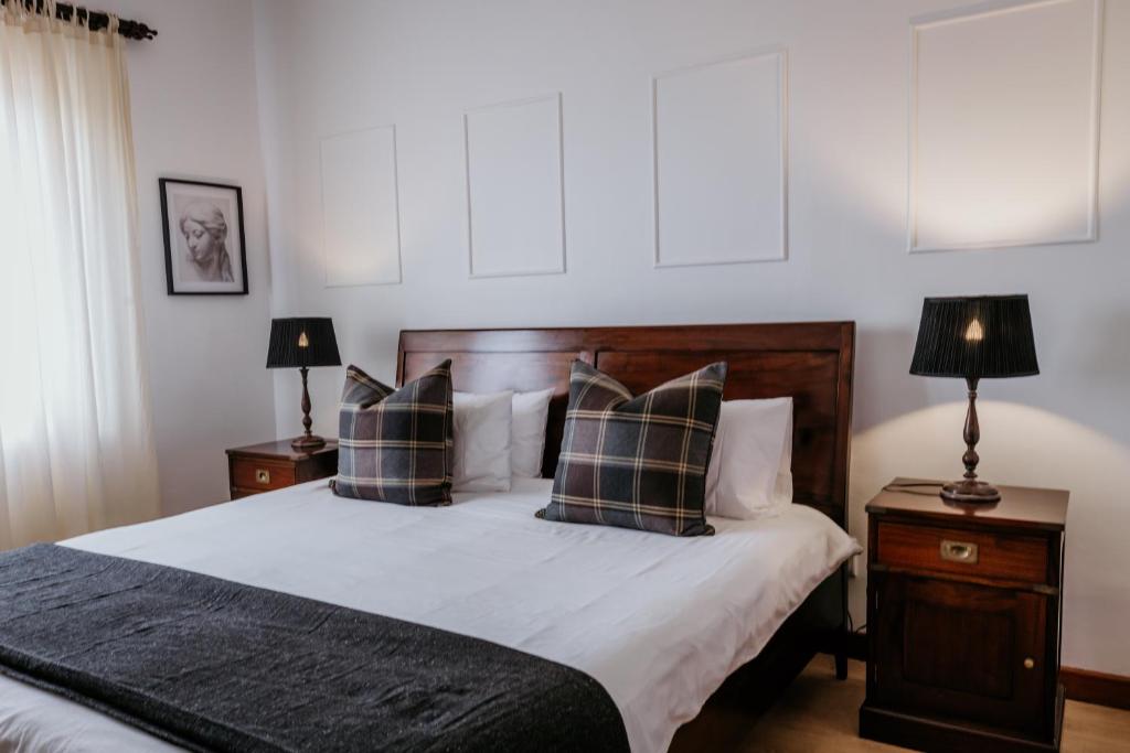1 dormitorio con 1 cama con almohadas y 2 lámparas en Fritz Manor Bed and Breakfast en Swakopmund
