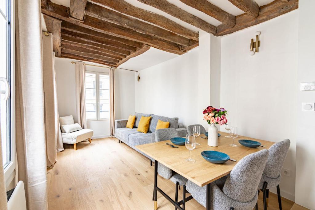 una sala da pranzo con tavolo e divano di Appartement Quartier Fontaine Chatelet Les Halles Free Netflix a Parigi