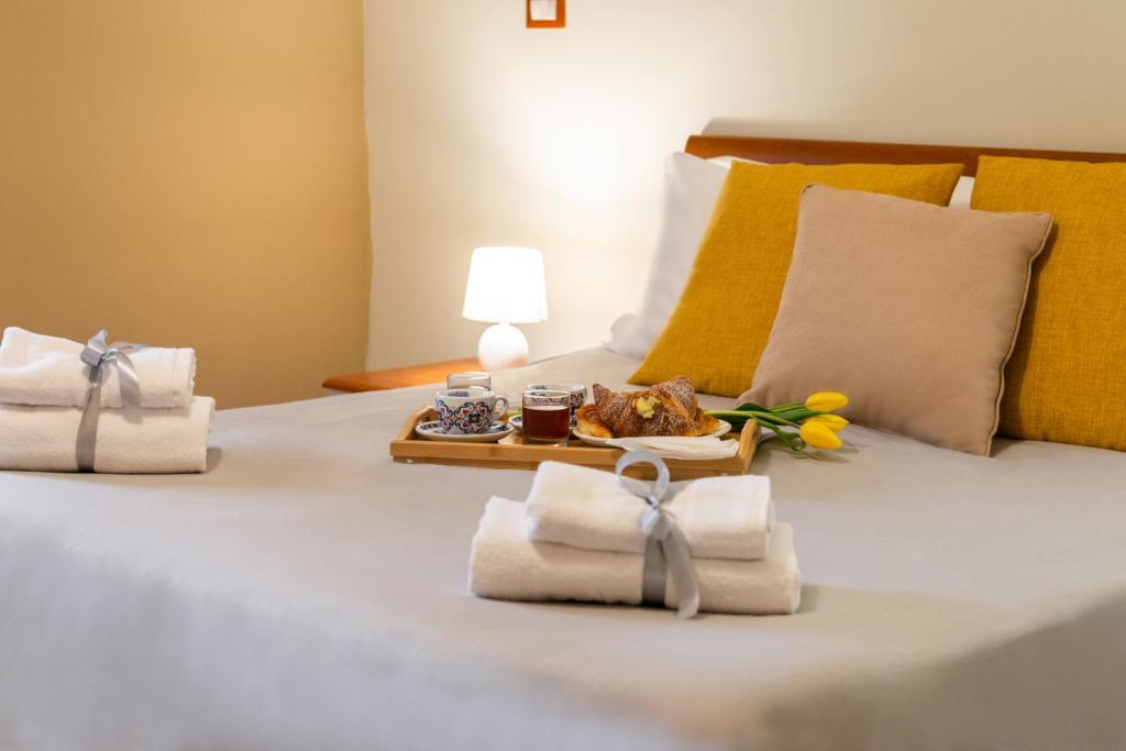 Una cama con toallas y una bandeja de comida. en Rome's Best Holidays Guest House en Roma