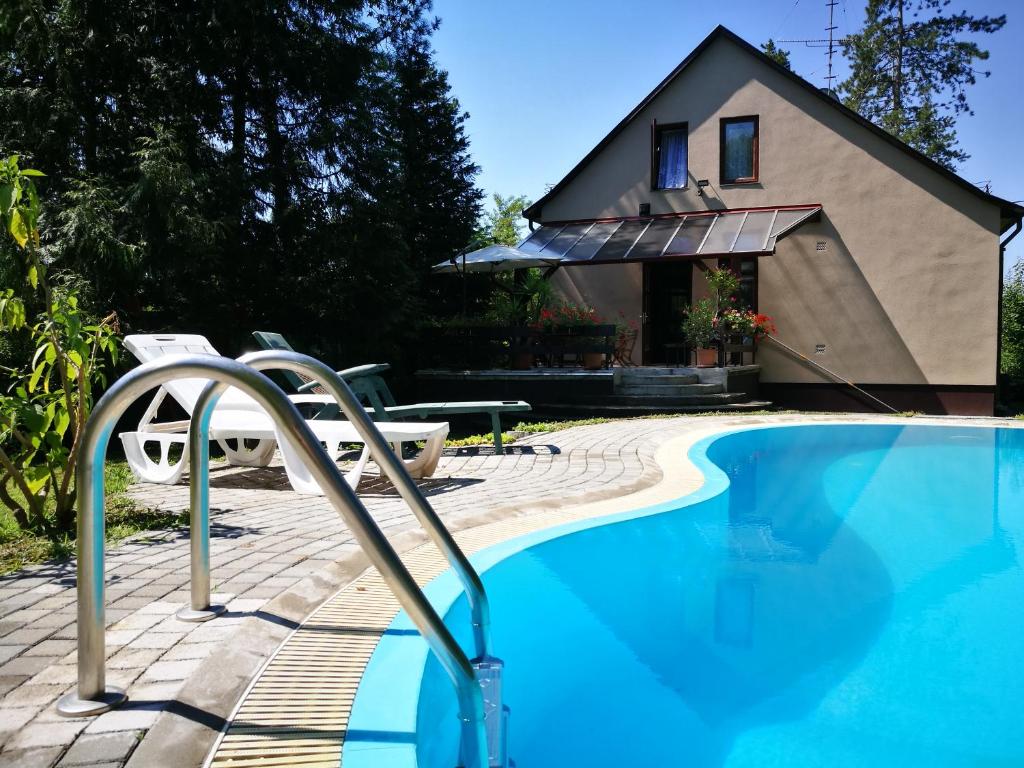 una piscina con una casa en el fondo en 3 Tó Sziki Szálló en Szeged