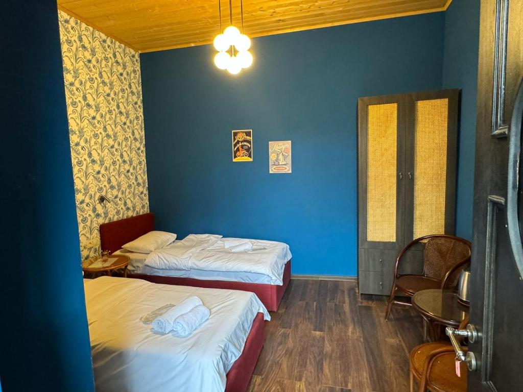 a room with two beds and a blue wall at Vintage room in Tbilisi City