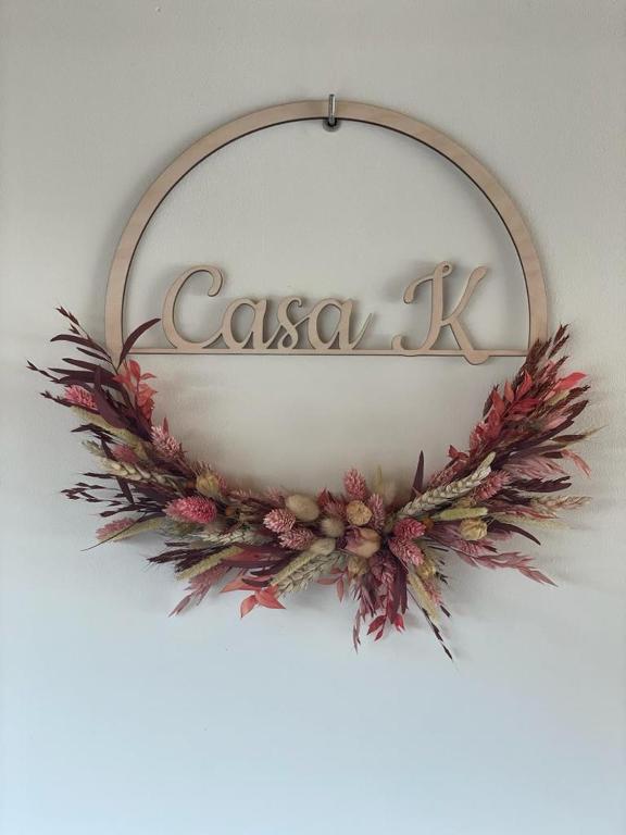 a sign on a wall with a flower wreath at Casa K in Middelkerke
