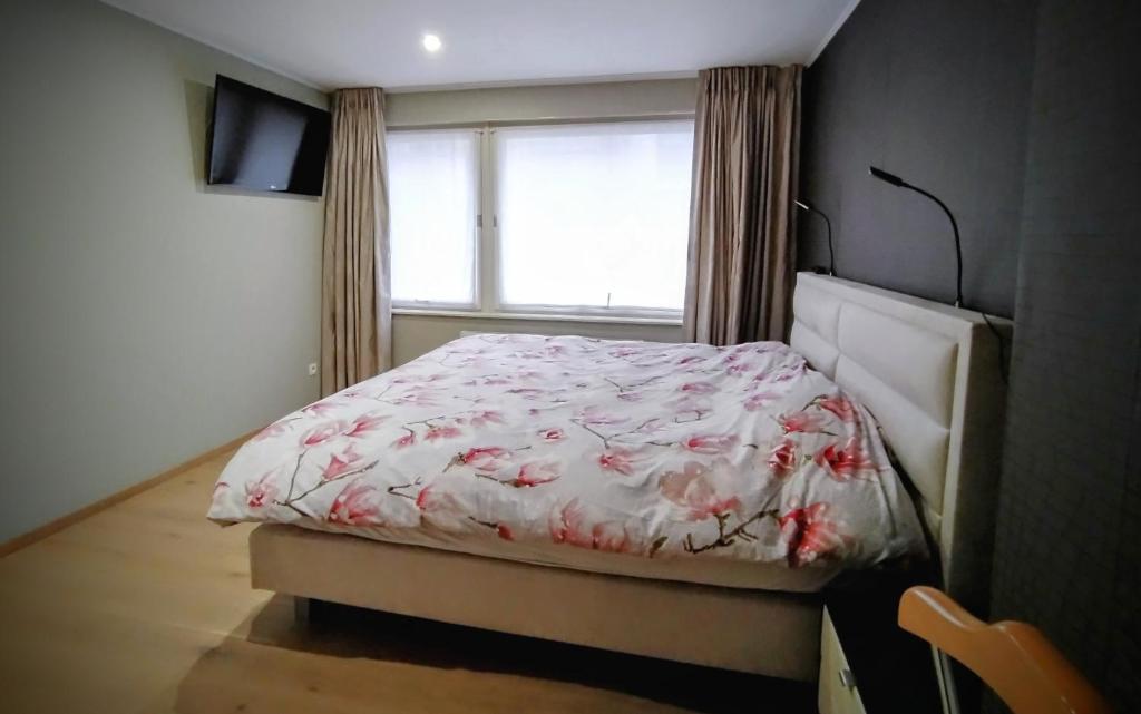 ein kleines Schlafzimmer mit einem Bett und einem Fenster in der Unterkunft Zonnezoen in De Panne
