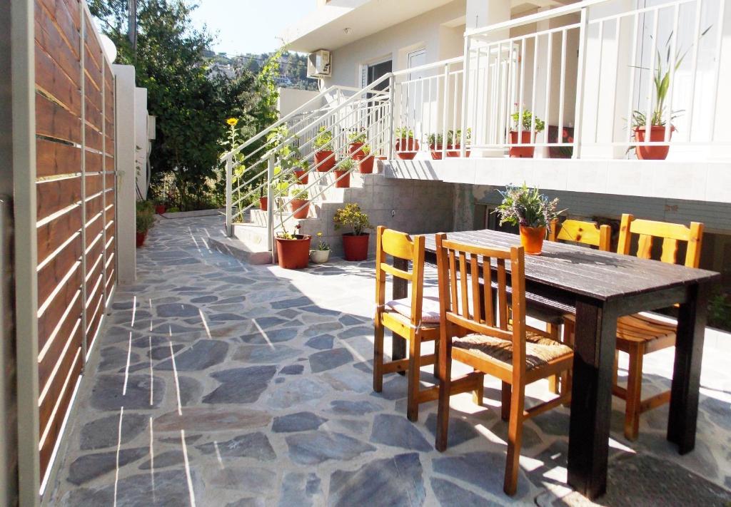 a patio with a wooden table and chairs on a balcony at ERA Studios in Skiathos