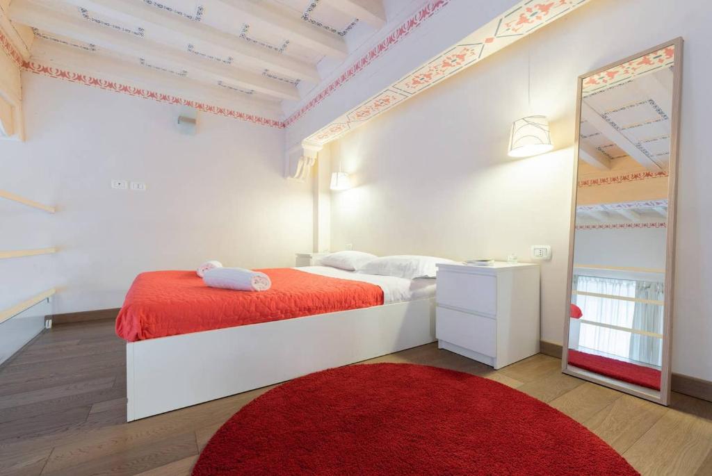 フィレンツェにあるGinori - 2 bedrooms apartment by Mercato Centraleのベッドルーム1室(赤い敷物と鏡付きのベッド1台付)