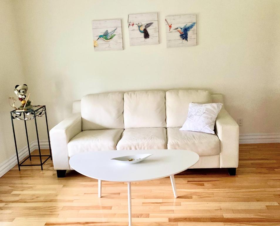 a living room with a white couch and a coffee table at Gîte Nycole in Perce