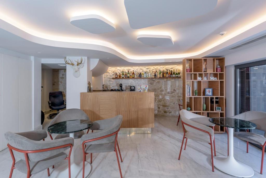 a living room with two glass tables and chairs at Iraklion Hotel in Heraklio Town