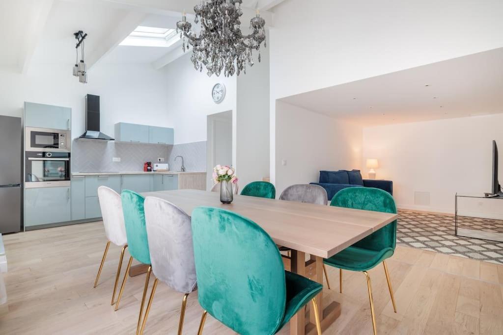 a dining room with a table and green chairs at Superbe appartement 8 personnes #5 in Asnières-sur-Seine